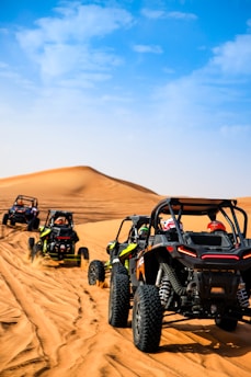 a group of four buggies driving through the desert