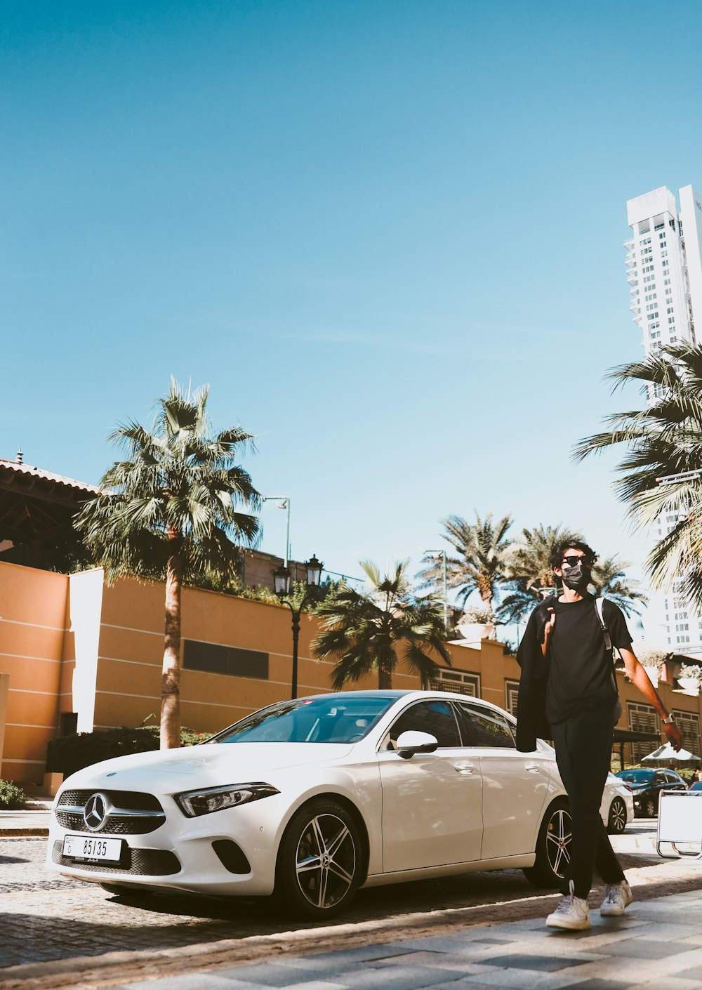 a man standing next to a white car