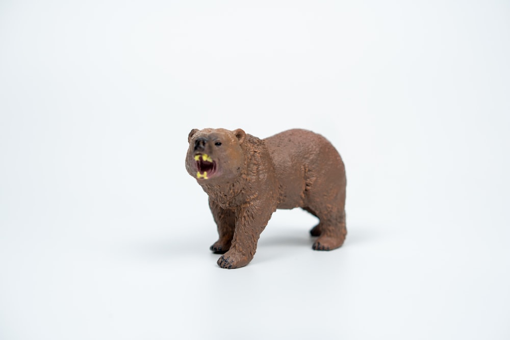 Una figurina di orso marrone su uno sfondo bianco