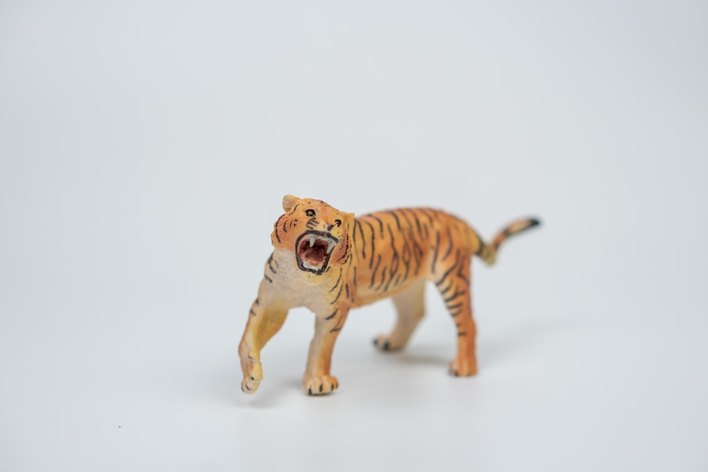 a toy tiger with its mouth open on a white background