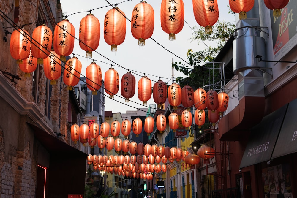a bunch of orange lanterns hanging from a wire