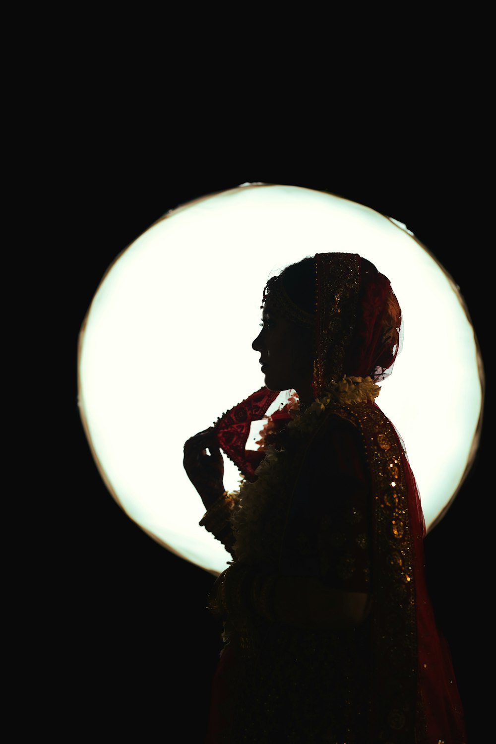a silhouette of a woman in a red and gold dress