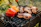 Happy customer spreading chimi gel on grilled meat at a sunny backyard barbecue.