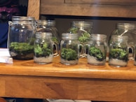 A neat arrangement of slime jars in various bright colors on a wooden table.