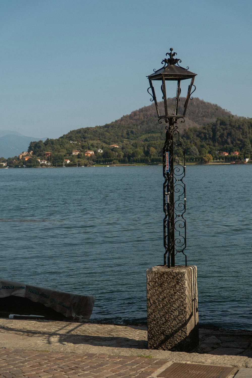 a lamp post next to a body of water