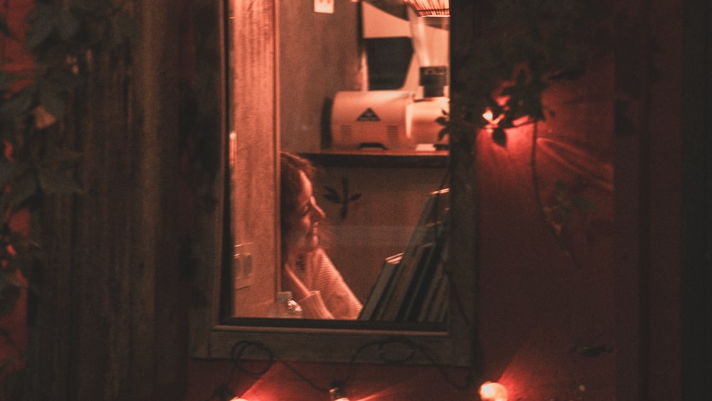 a mirror reflecting a woman's reflection in a bathroom