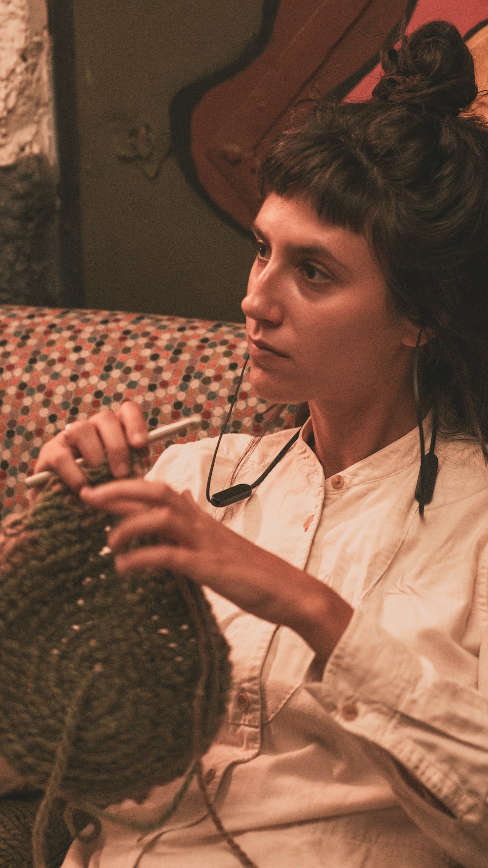 a woman sitting on a couch holding a ball of yarn