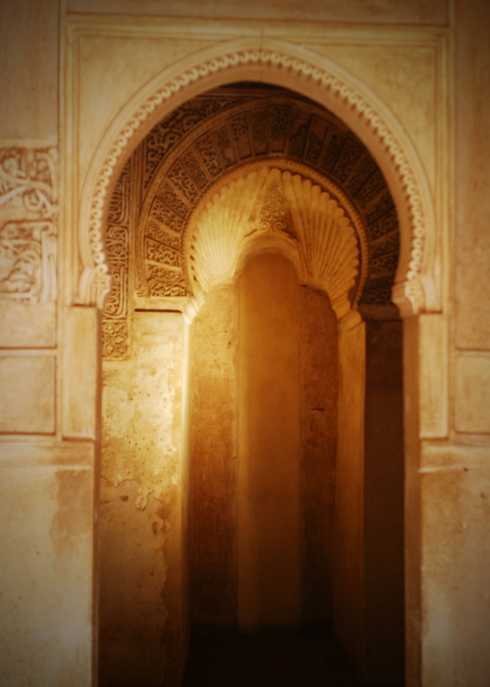 an archway in a stone building with a light coming through it