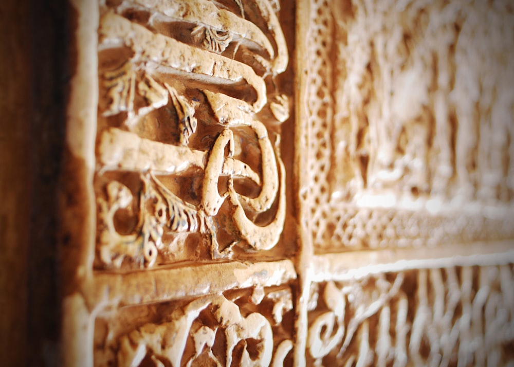 a close up of a wall with carvings on it