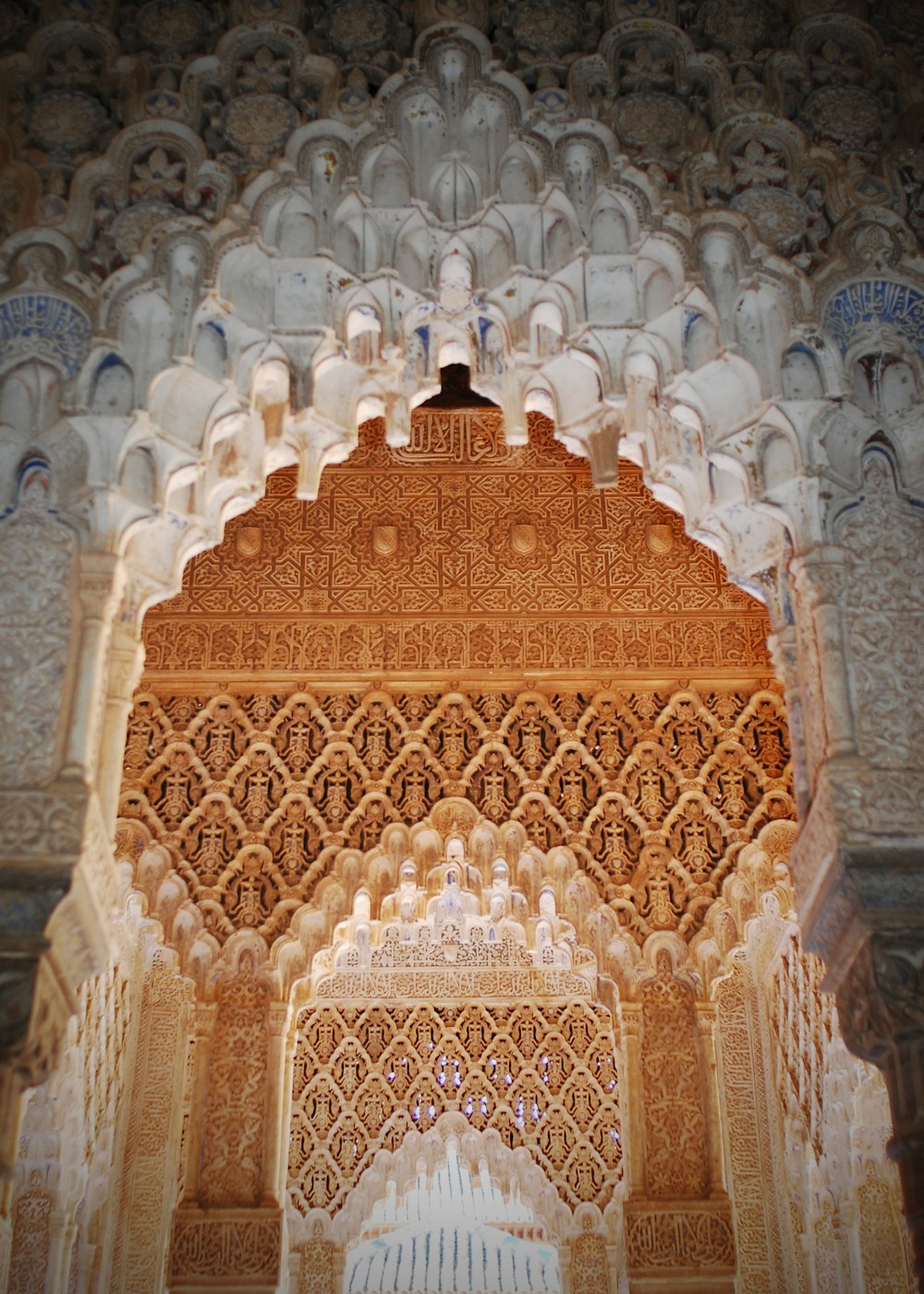 an ornate wall with a bell in the middle of it