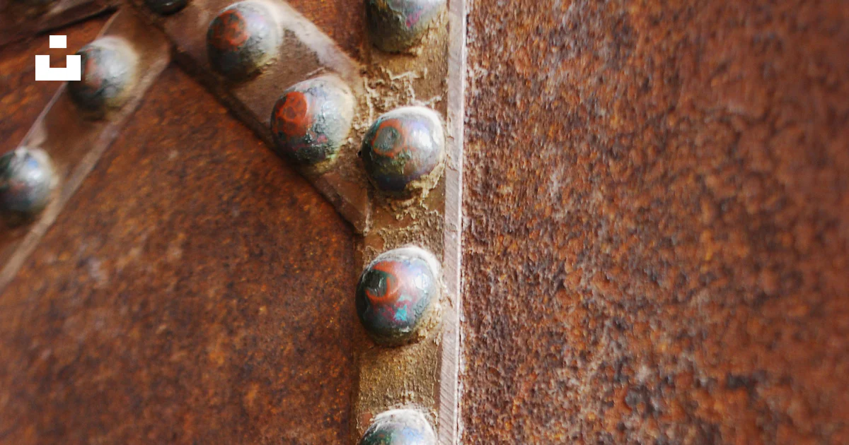 A rusted metal surface with rivets and rivet holes photo – Free Door ...
