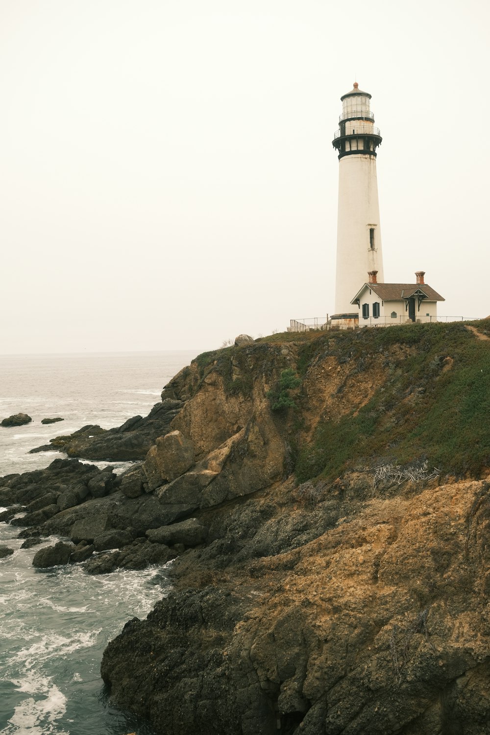 a light house sitting on top of a cliff next to the ocean