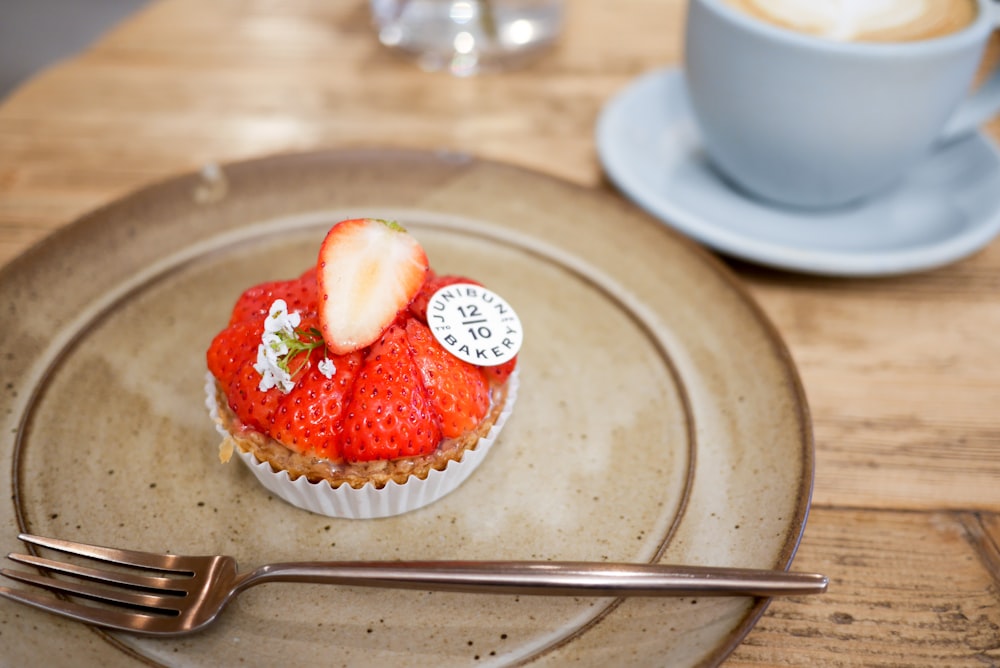 a cupcake with strawberries on top on a plate