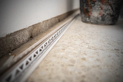 Wide shot of a spacious living room floor with large tiles and neat epoxy grout lines.