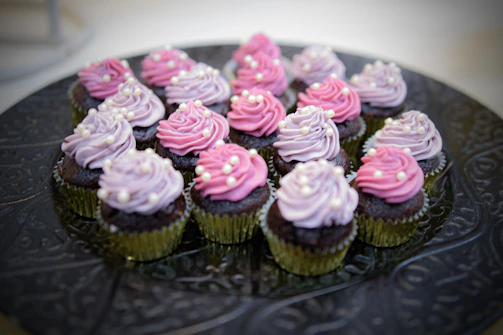 A tray of assorted cupcakes with creamy frosting and charming toppings, ready to delight.