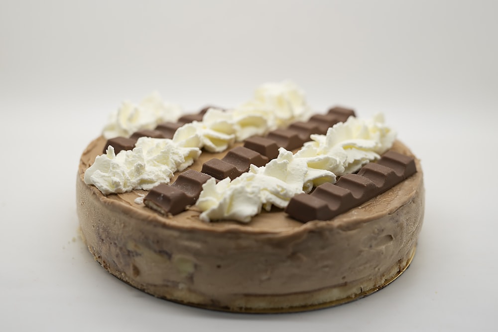 a chocolate cake topped with whipped cream and chocolate bars