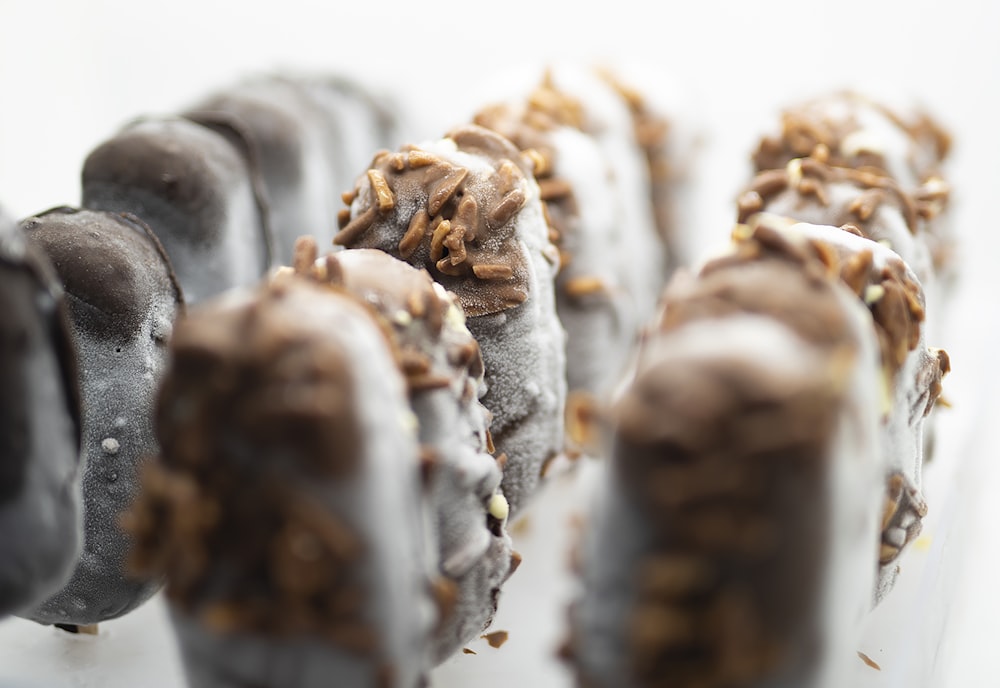 a row of chocolate covered donuts with sprinkles