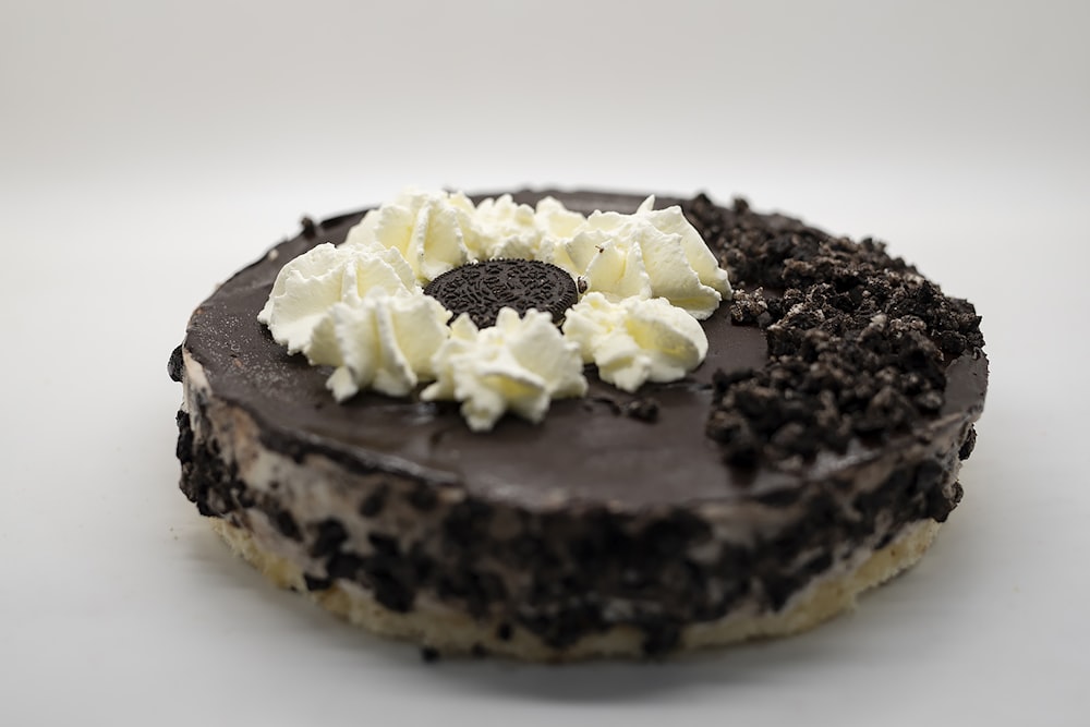 a chocolate cake topped with whipped cream and chocolate chips