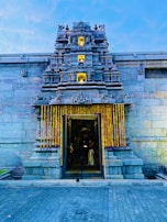 A traditional temple entrance in Ayodhya framed by blooming marigold garlands.
