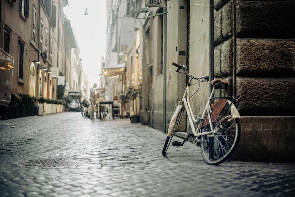 a bicycle parked on a cobblestone street