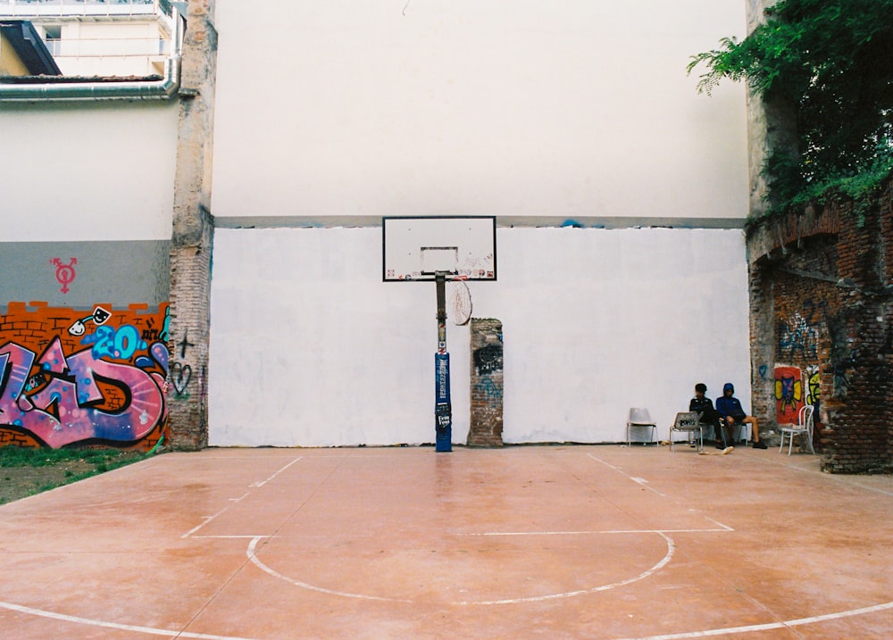 a basketball court with graffiti on the wall