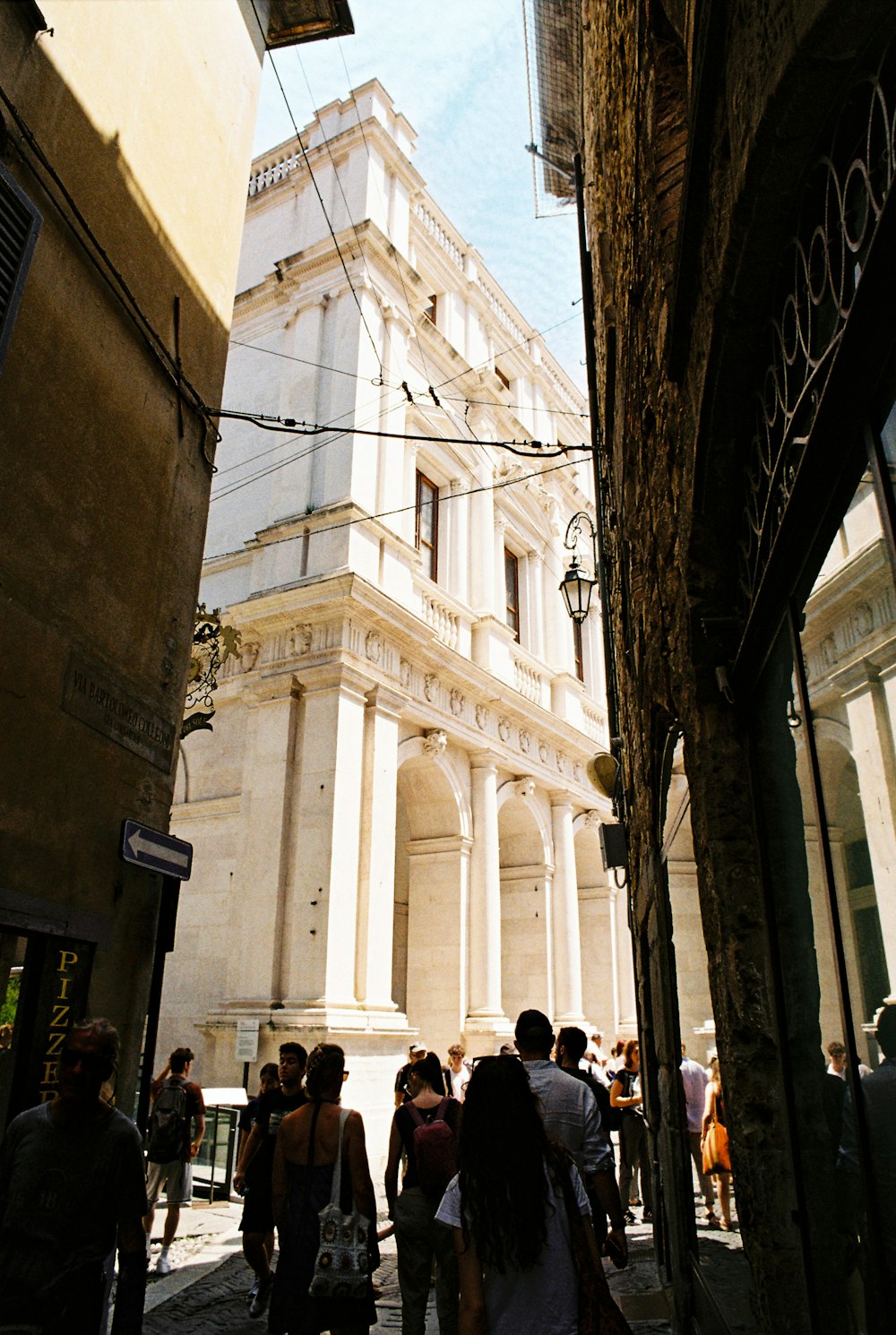 a group of people walking down a street next to a tall building