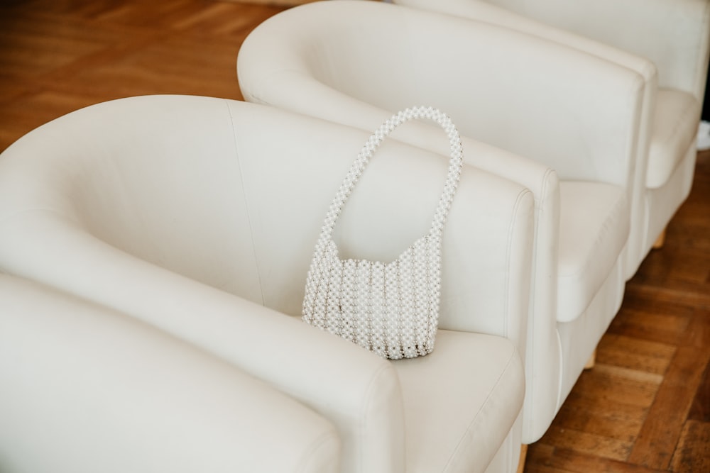 a white purse sitting on top of a white couch