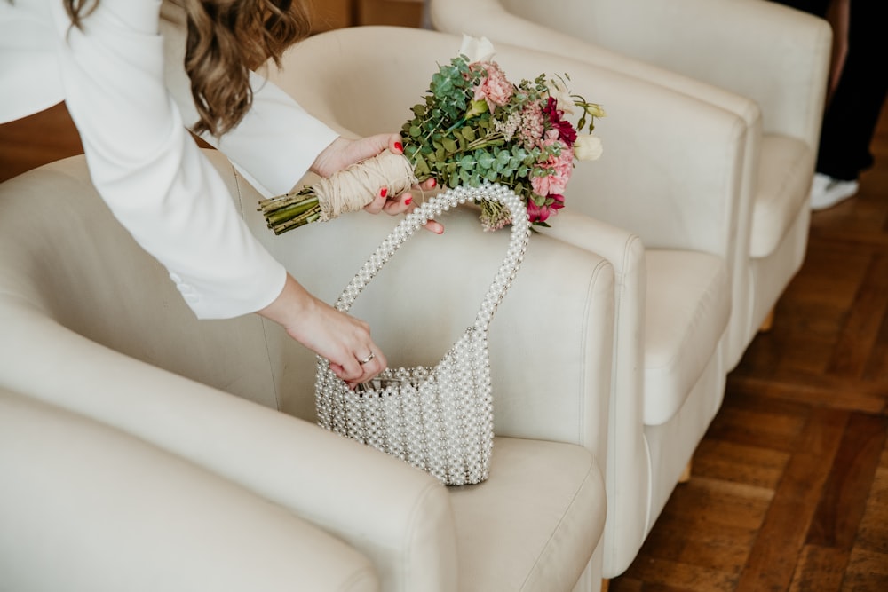 a woman holding a bouquet of flowers on a chair