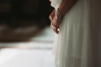 Close-up of a flowing pale dusty lavender dress with subtle luminous details under soft lighting.