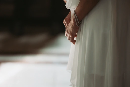 Close-up of a flowing pale dusty lavender dress with subtle luminous details under soft lighting.