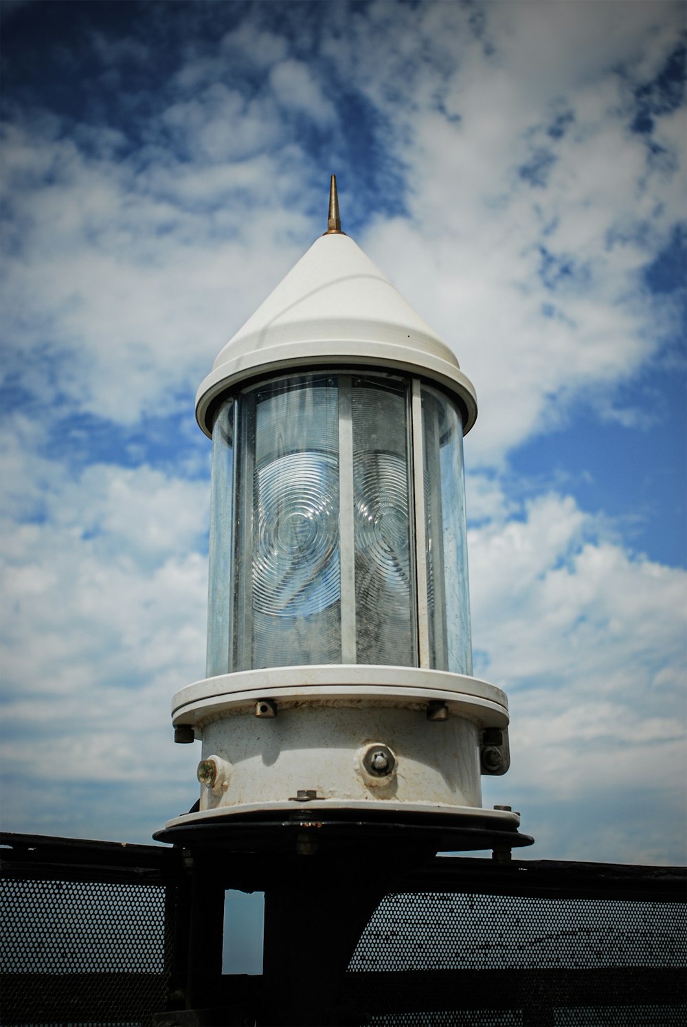 a white lighthouse with a blue sky in the background