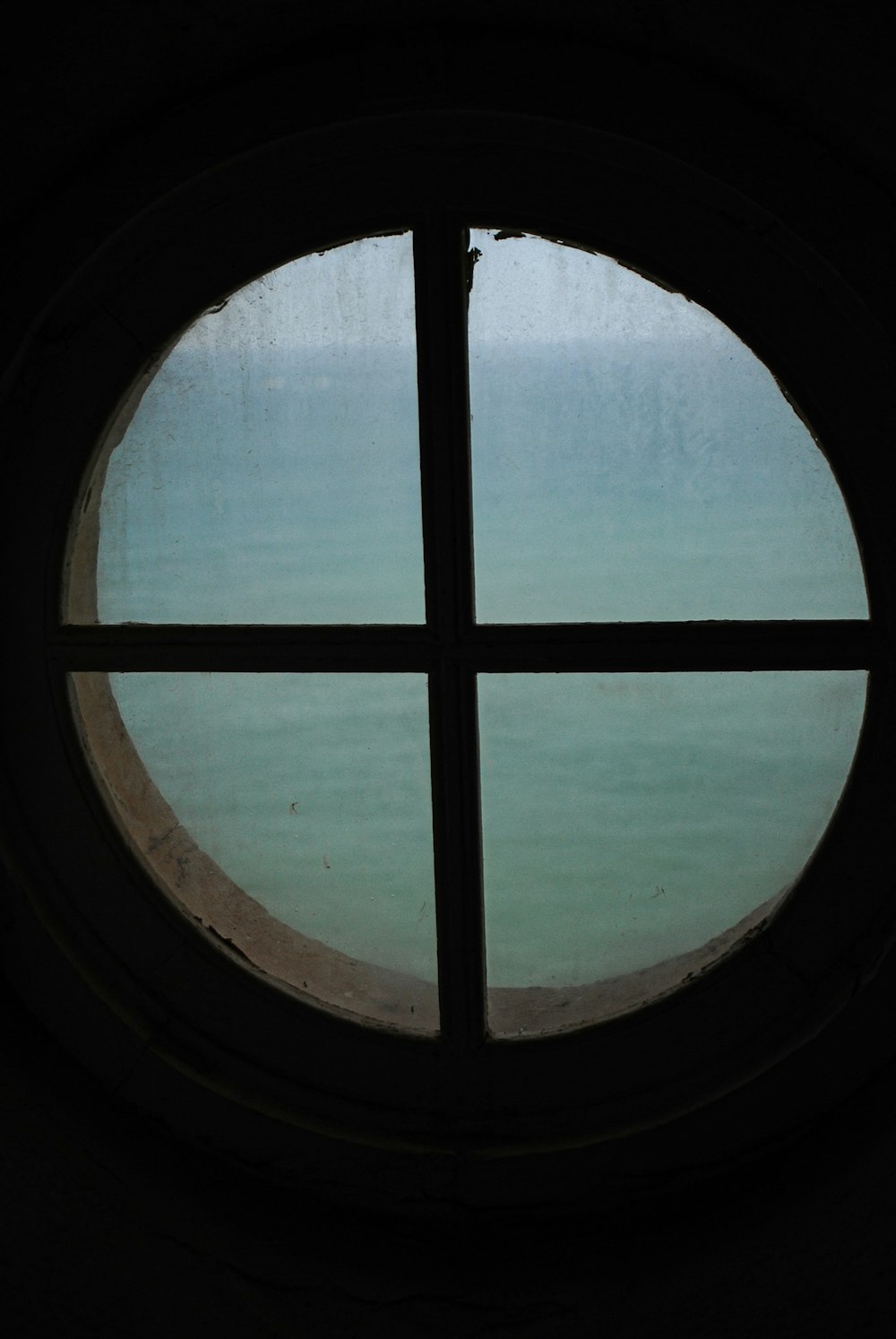 a round window with a view of a body of water