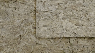 An image of overlapping sheets of oriented strand board (OSB), which consists of compressed wood strands arranged in varied directions.