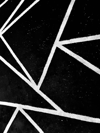 Minimalist geometric lines intersecting at odd angles on a white canvas.
