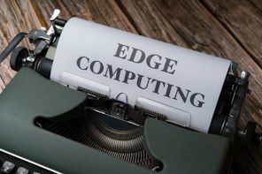 a close up of a typewriter with a paper reading edge computing