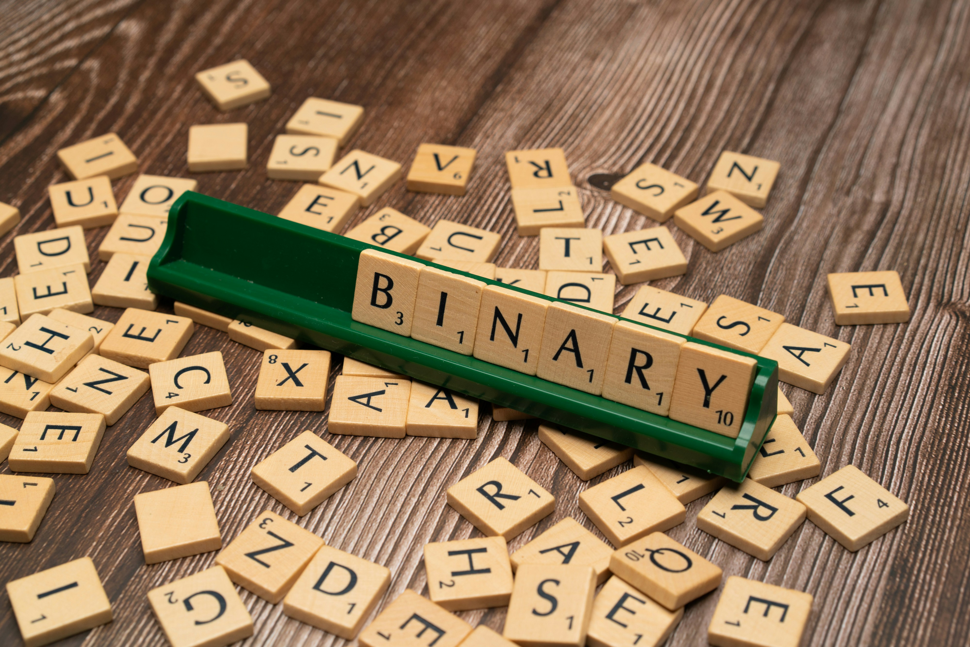 scrabble tiles spelling the word library on a wooden table