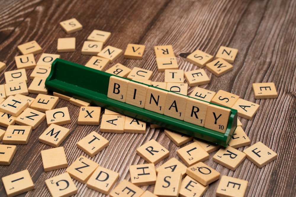 scrabble tiles spelling the word library on a wooden table