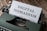 A vintage typewriter with a sheet of paper in its platen. The paper has the words 'DIGITAL NOMADISM' typed in bold, clear letters. The typewriter is placed on a rustic wooden surface, conveying a blend of nostalgia and modernity.