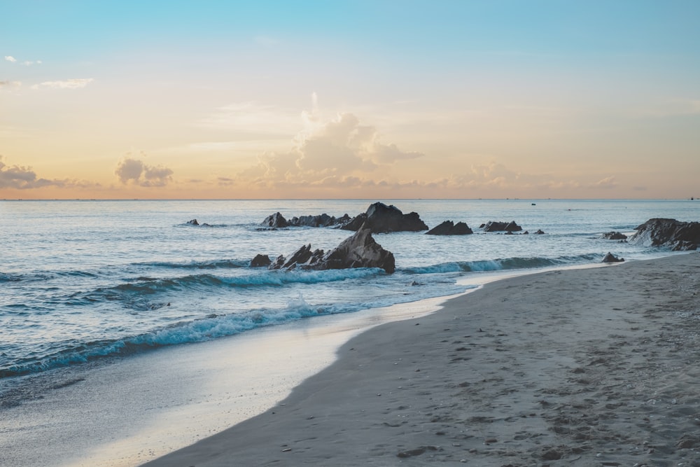 a beach that has some rocks in the water