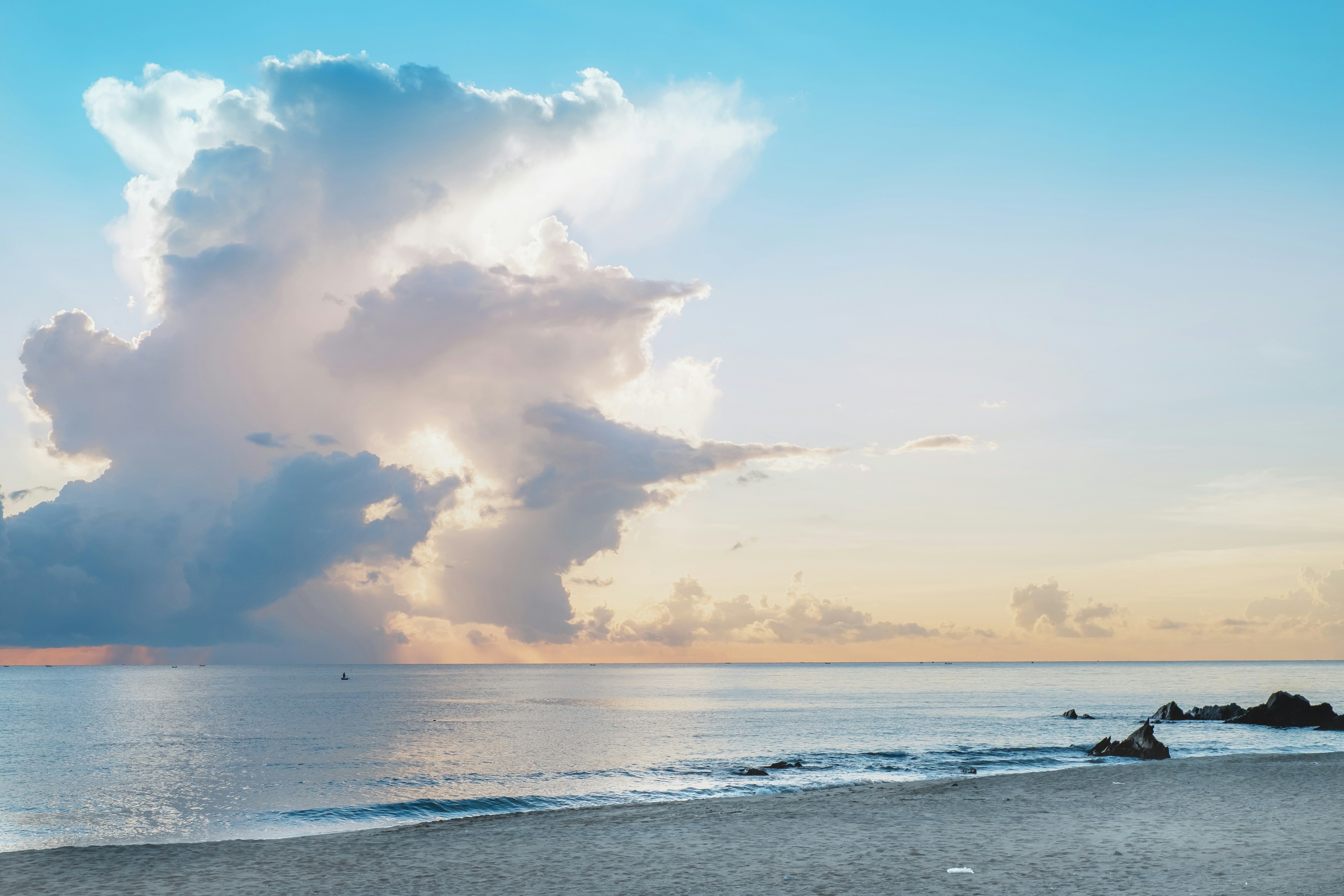 Un gros nuage est dans le ciel au-dessus d’une plage photo – Image ...