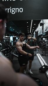 Close-up of a bodybuilder practicing a pose in front of a mirror.