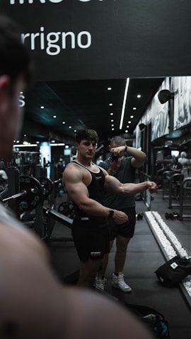 Close-up of a bodybuilder practicing a pose in front of a mirror.