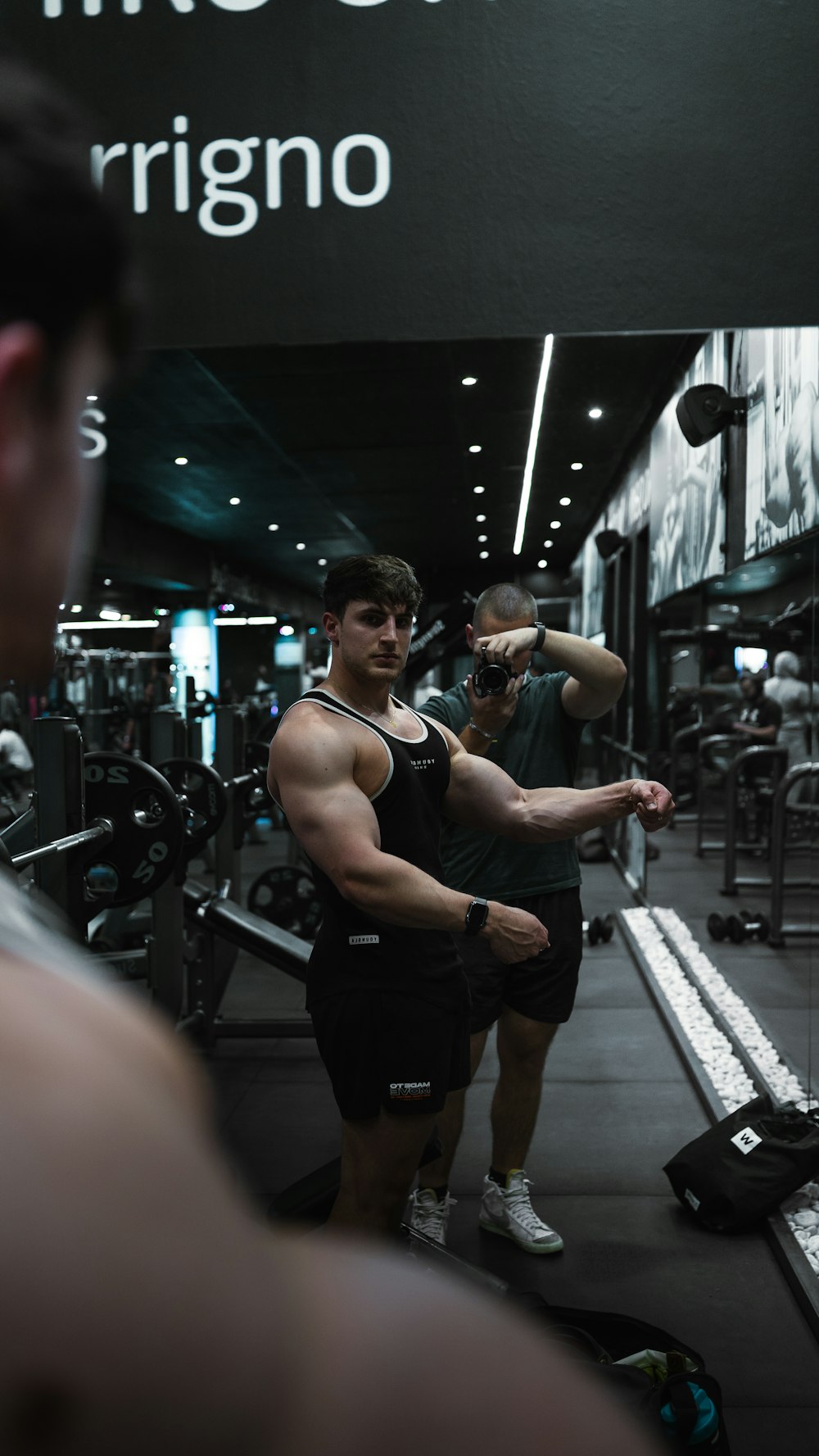 a man standing next to another man in a gym