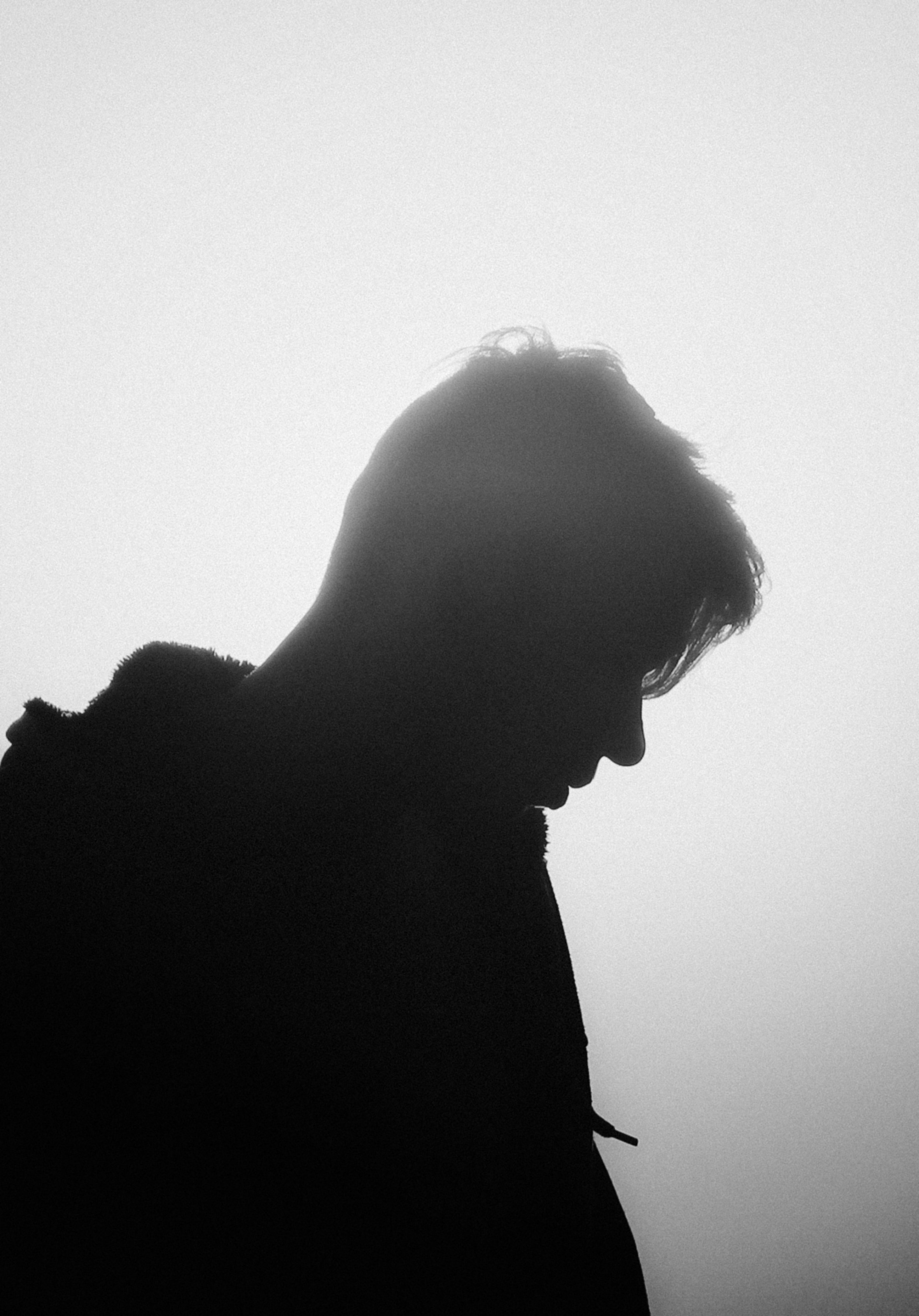 a black and white photo of a person with a cell phone