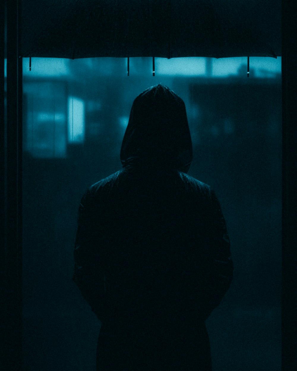 a person standing in a dark room with an umbrella