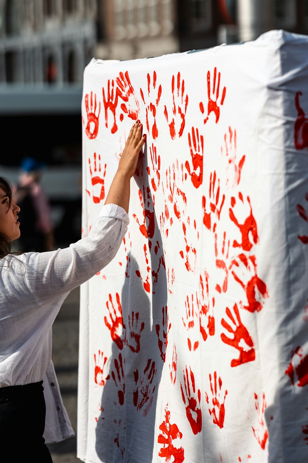 a woman is painting on a large white sheet