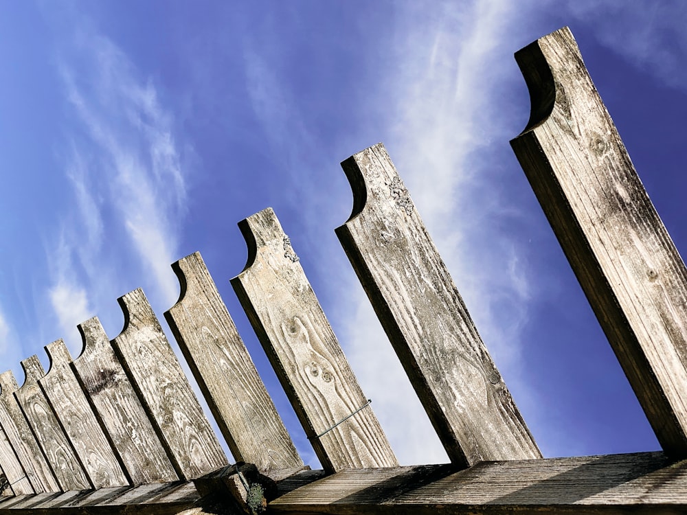 a row of wooden posts against a blue sky