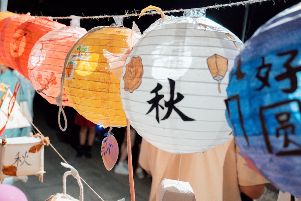 a group of paper lanterns hanging from a line