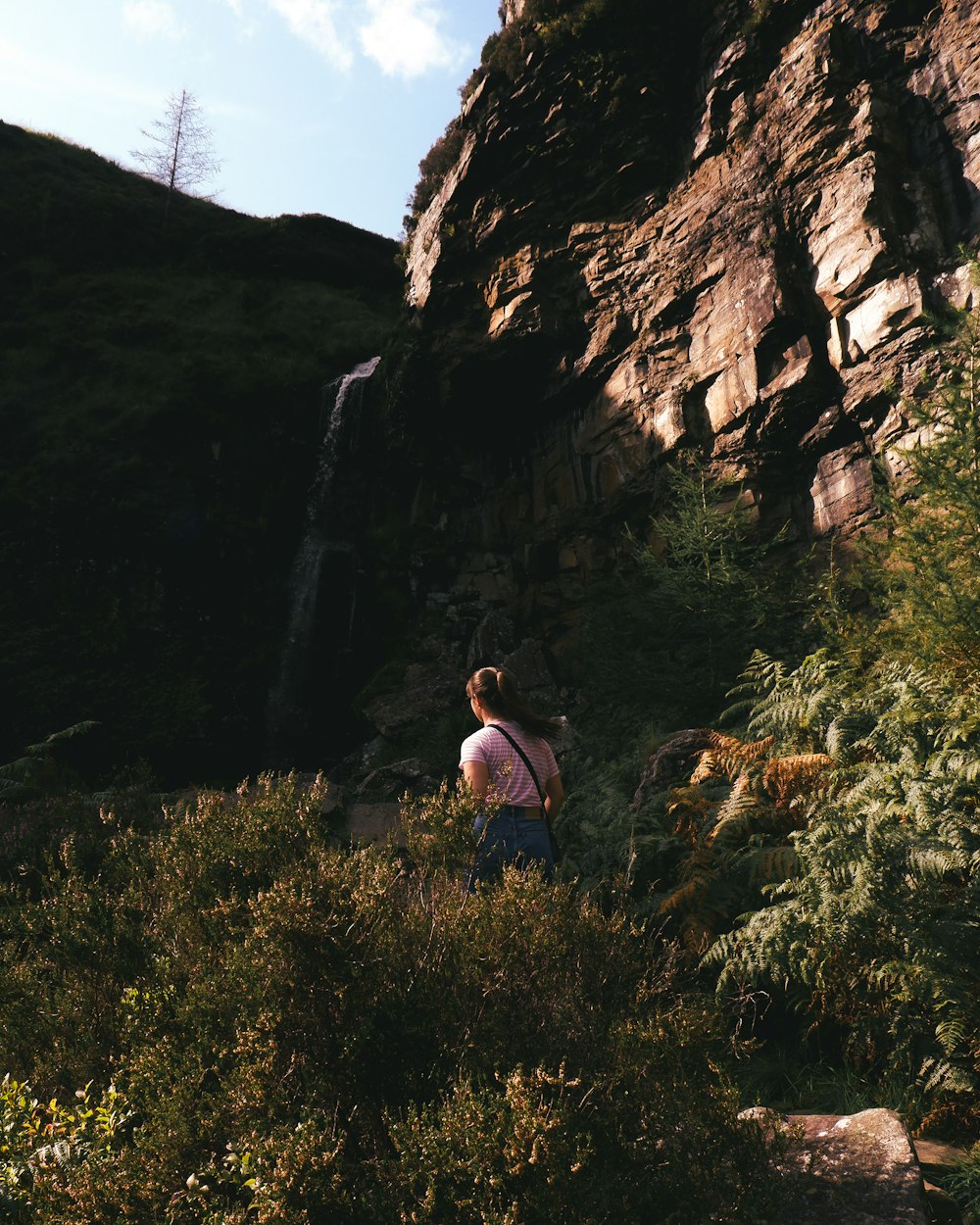 a woman standing in front of a waterfall