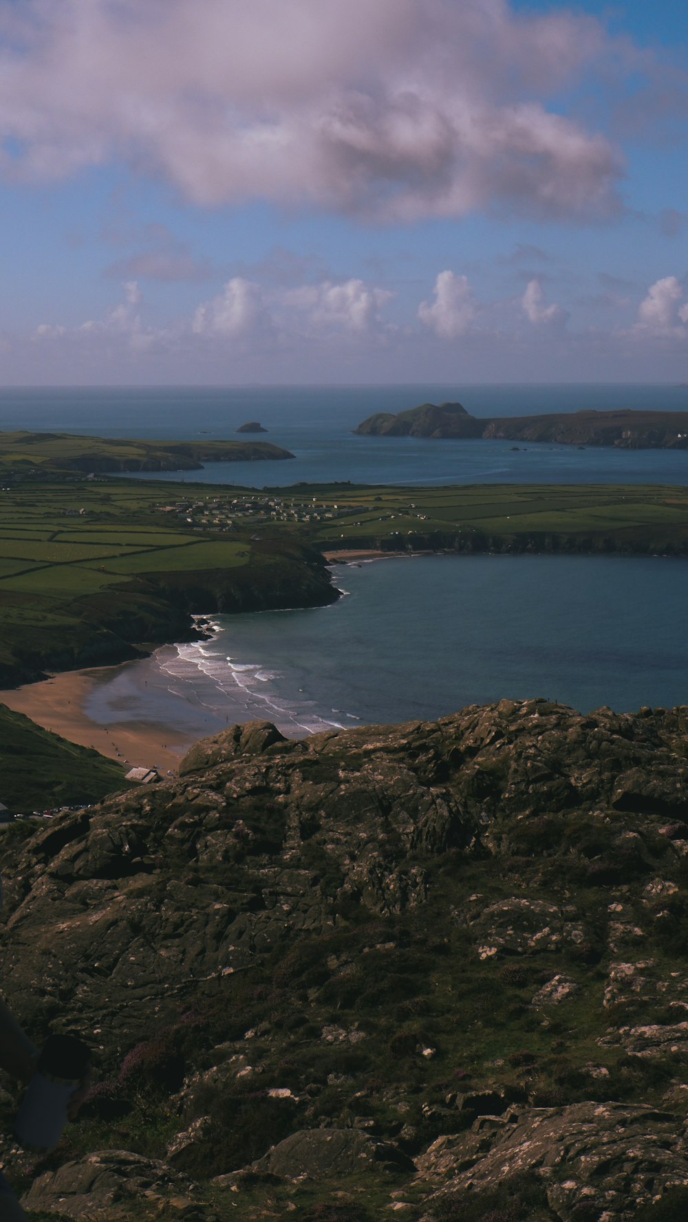 a large body of water sitting next to a lush green hillside